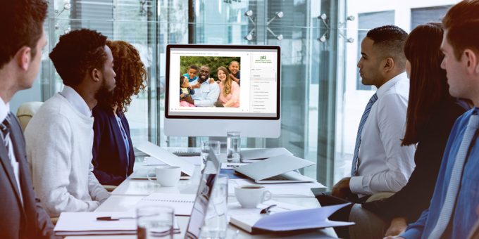 people sitting around table viewing NTI website